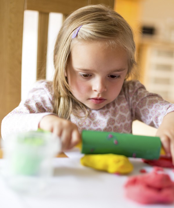 girl playing with play dough doh